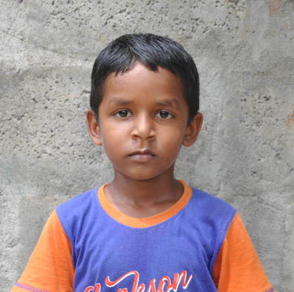 Little Indian boy with a blue and orange shirt rescued from slavery or human trafficking