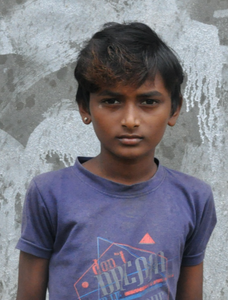 Little Indian boy with a blue shirt rescued from slavery or human trafficking