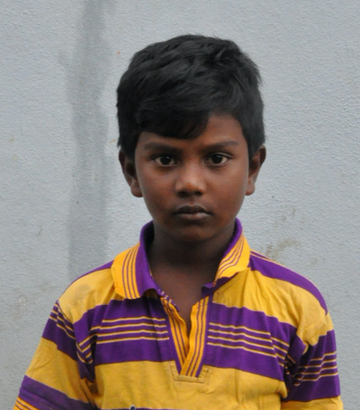 Little Indian boy with a purple and yellow shirt rescued from slavery or human trafficking