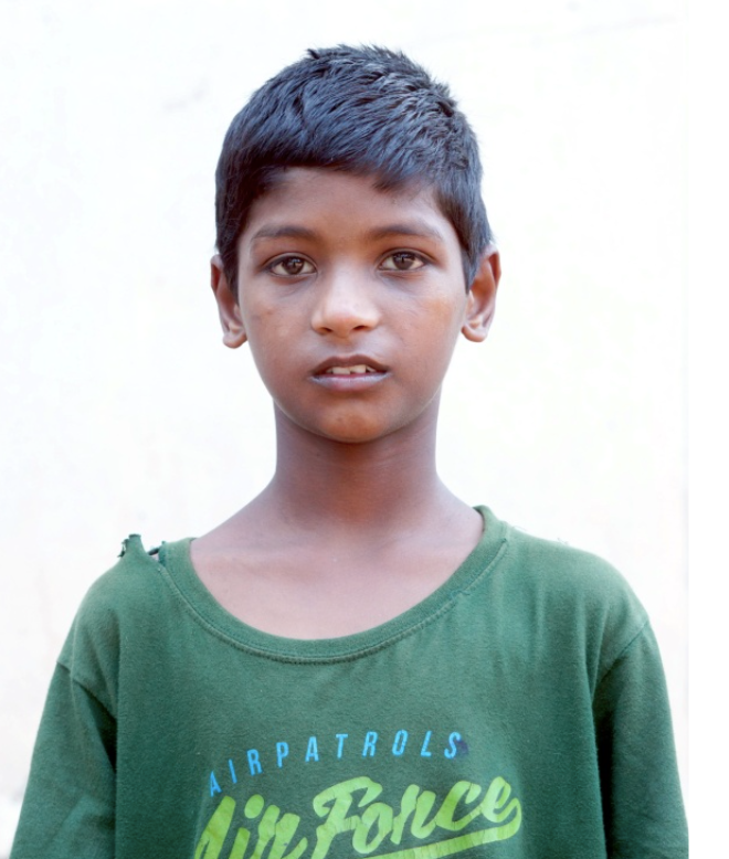 Little Indian boy with a green shirt rescued from slavery or human trafficking