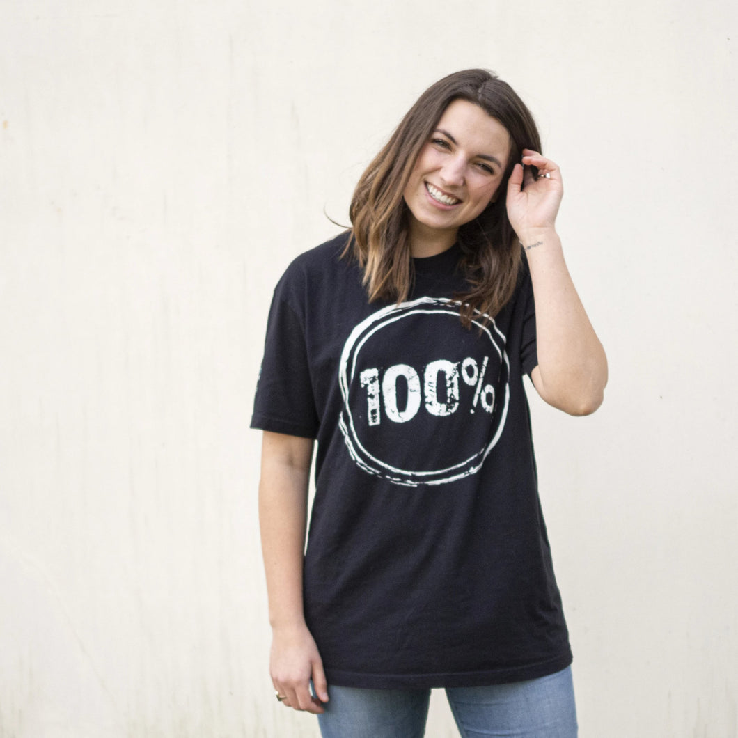 Young woman wearing a black shirt with “100%” on the front to represent our commitment to being a 100% non-profit to fight human trafficking